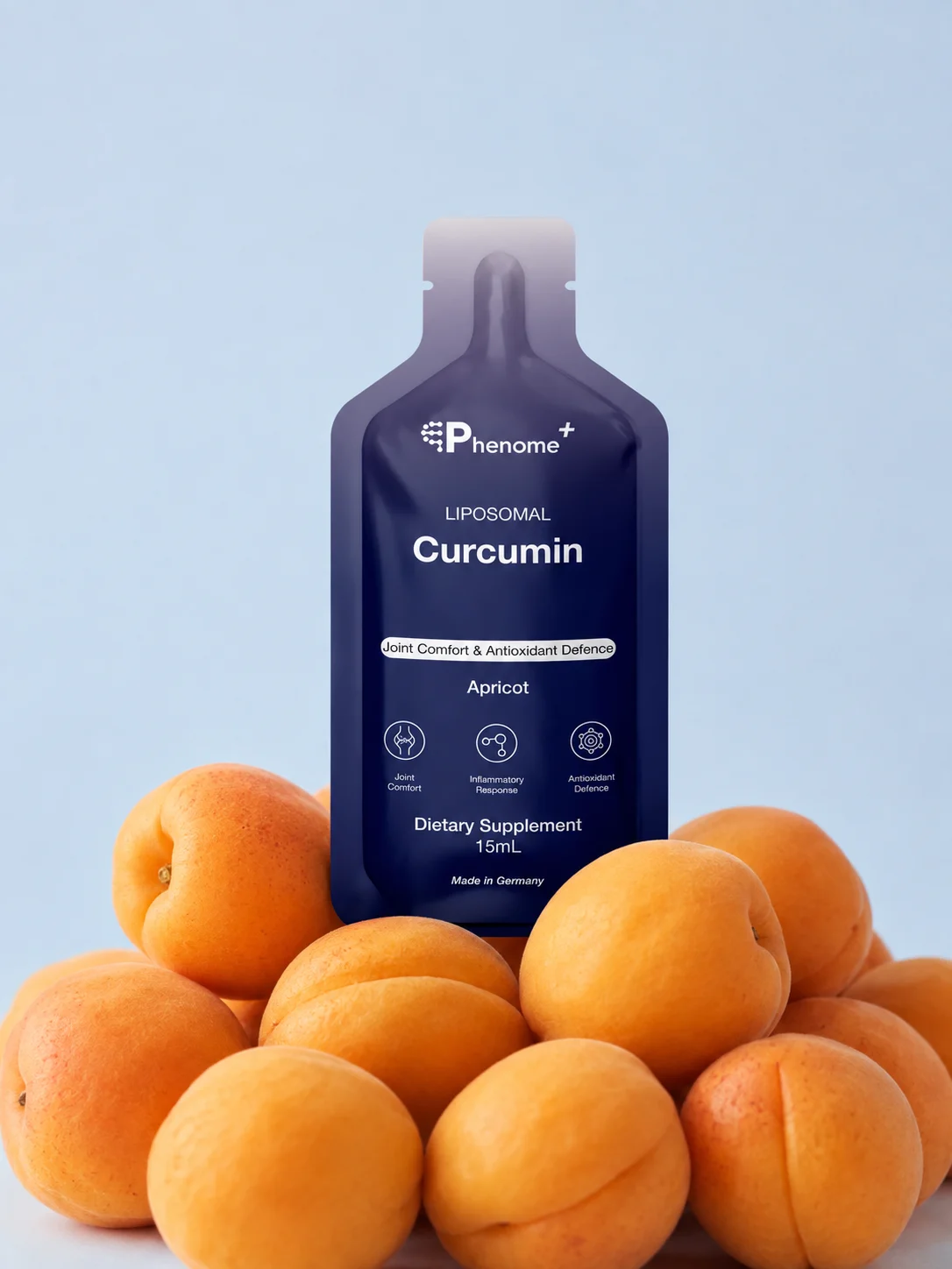 A sachet of Phenome+ Liposomal Curcumin standing on a pile of apricots